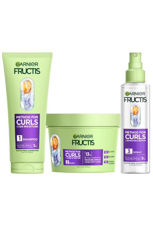 A complete set of Garnier Fructis Method for Curls products is displayed: a light green tube of “Moisture Restoring Shampoo“, a light green tub of “Defining Mask“ and a clear spray bottle of “Reviving Spray" for 48H moisture & definition and for up to 1 week of moisture. All products highlight "Hyaluronic Moisture Complex + Shea Fatty Acids."